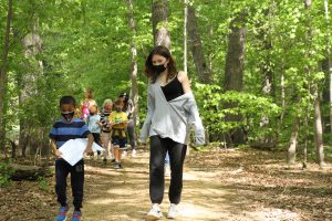 Upper and Lower School students walking in woods