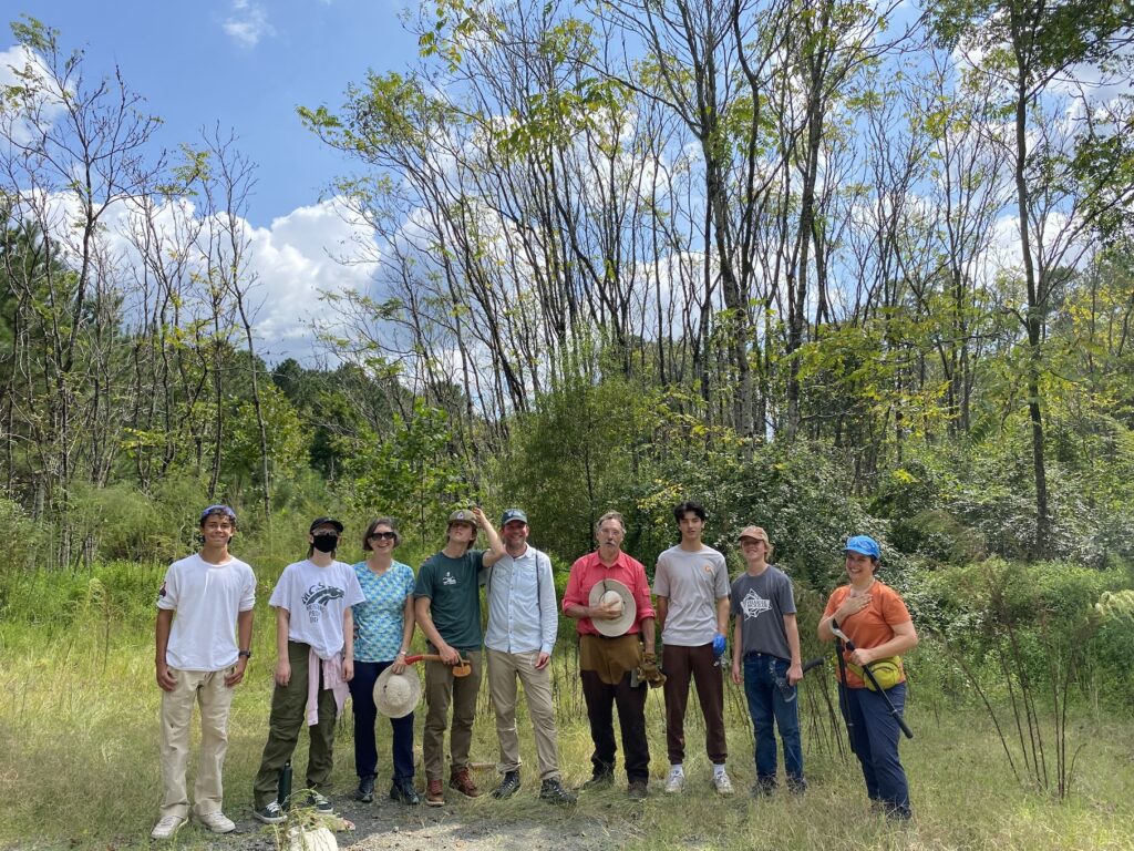 Group of students, parents, & faculty on beautiful day in forest